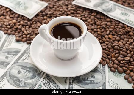 Tasse Kaffee auf Kaffeebohnen und Dollar-Banknoten Hintergrund Stockfoto