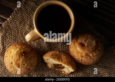 Draufsicht auf Dulce de leche Karamellmuffins mit Kaffee auf einer Sackleinen-Oberfläche Stockfoto