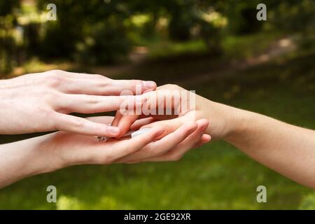 Mann und Frau halten die Hände. Hände aus der Nähe. Am Sommertag draußen Stockfoto