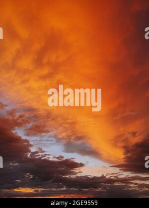 Farbenprächtiger Sonnenuntergang im Herbst. Vertikaler Hintergrund, abstrakte Wolken Formen und Farben. Oktober saisonale himmlische Schönheit. Panoramaszene in der Dämmerung Stockfoto