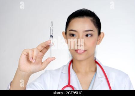 Die Ärztin hielt eine Spritze, um die Injektionen oder den Impfstoff COVID-19 für die Patienten vorzubereiten. Stockfoto