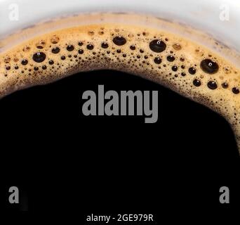 Kaffeeschaum extreme Nahaufnahme. Makro-Textur und Hintergrund. Draufsicht auf eine Tasse Kaffee. Stockfoto