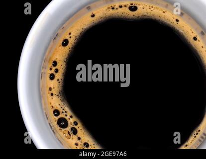 Kaffeeschaum extreme Nahaufnahme. Makro-Textur und Hintergrund. Draufsicht auf eine Tasse Kaffee. Stockfoto