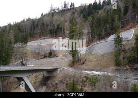 Serpentinenstraße auf einem Berghang in der Region Versam in der Schweiz. Nahaufnahme oder Detailansicht. Es gibt auch eine Brücke über den Fluss Rabiusa. Stockfoto