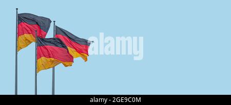Banner mit drei nationalen schwarz rot gelben Flaggen Deutschlands im Wind und am blauen Himmel Hintergrund mit Kopierfläche, Details, Nahaufnahme. Konzept der nationalen Stockfoto