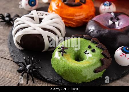 Assortmen von Halloween Donuts auf Holztisch Stockfoto