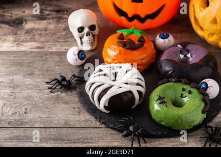 Assortmen von Halloween Donuts auf Holztisch Stockfoto