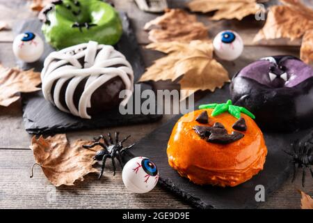 Assortmen von Halloween Donuts auf Holztisch Stockfoto