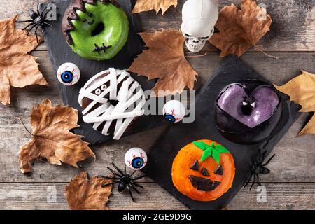 Assortmen von Halloween Donuts auf Holztisch Stockfoto