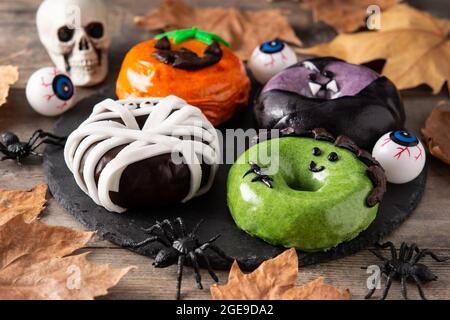 Assortmen von Halloween Donuts auf Holztisch Stockfoto