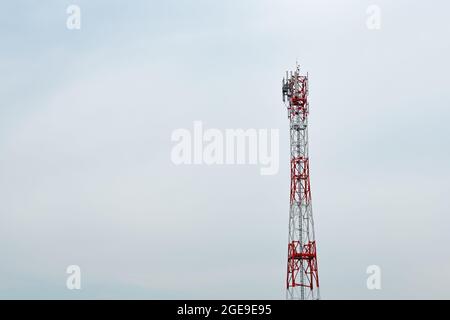 Telekommunikationsturm mit Antennen und Signalrepeatern gegen bewölkten Himmel als Kopierraum Stockfoto