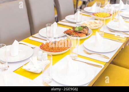 Abendessen mit afrikanischen Gerichten mit Jollof-Reis Stockfoto