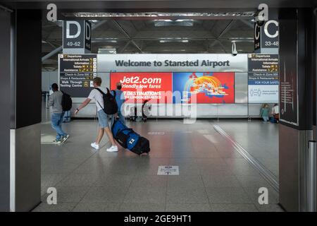 August 2021, London, Großbritannien. Eine moderate Anzahl von Reisenden wird am Flughafen London Stansted vorbeikommen sehen. Während der doppelte Impfstatus und ‘der „NHS Covid Pass“ für einige Reisen geradliniger gemacht haben, gibt es für andere erhebliche Frustration über die Kosten und Ineffizienz von obligatorischen privaten PCR-Tests vor dem Flug. London, Großbritannien Kredit: Joshua Windsor/Alamy Live News Stockfoto