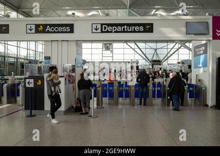August 2021, London, Großbritannien. Eine moderate Anzahl von Reisenden wird am Flughafen London Stansted vorbeikommen sehen. Während der doppelte Impfstatus und ‘der „NHS Covid Pass“ für einige Reisen geradliniger gemacht haben, gibt es für andere erhebliche Frustration über die Kosten und Ineffizienz von obligatorischen privaten PCR-Tests vor dem Flug. London, Großbritannien Kredit: Joshua Windsor/Alamy Live News Stockfoto