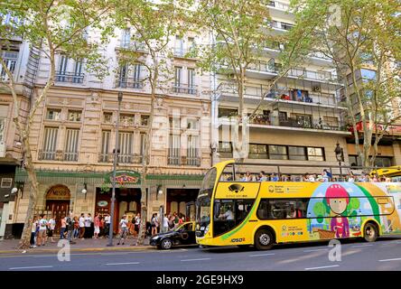 Eine Gruppe von Menschen wartet darauf, das Cafe Tortoni, ein historisches Kaffeehaus in Buenos Aires, mit einem Hop-on-Hop-off-Touristenbus im Vordergrund, Argentinien, zu betreten Stockfoto