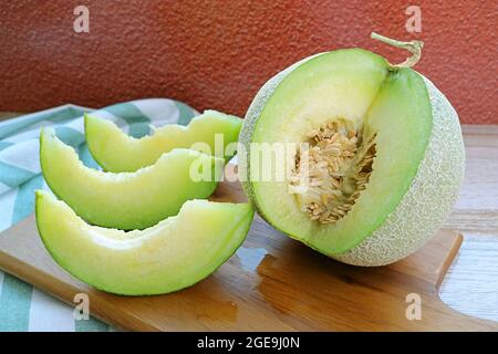 Frische, reife, süße und aromatische Muskmelone mit ganzen Früchten auf einem Holzbrett Stockfoto