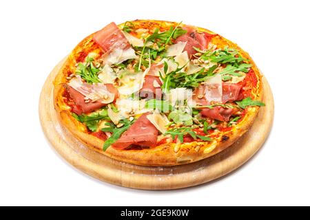 Pizza mit trockenem Schinken, Parmesankäse, Rucola-Blättern und ipne-Nüssen auf Holzplatte, isoliert auf weißem Hintergrund mit Schneideweg Stockfoto