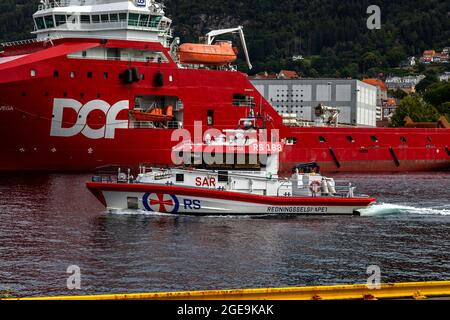 Hochgeschwindigkeit-Seerettungsboot Kristian Gerhard Jebsen II im Hafen von Bergen, Norwegen. Vorbeifahrende Offshore-Versorgungsschiff Skandi vega Stockfoto