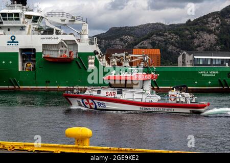 Hochgeschwindigkeit-Seerettungsboot Kristian Gerhard Jebsen II im Hafen von Bergen, Norwegen. Vorbeifahrende Offshore-Versorgungsschiff Havila Venus Stockfoto