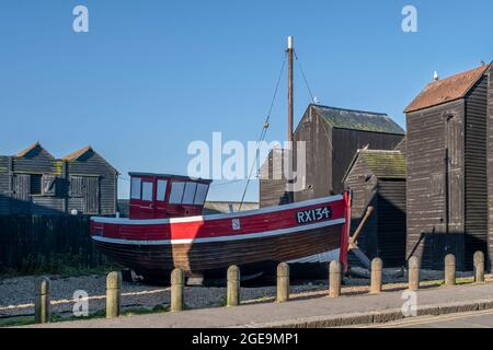 Ein altes Fischerboot inmitten der Net Shops auf dem Hastings Heritage Trail. Stockfoto