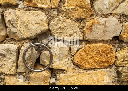 Steinmauer mit kreisförmigem Metallring zum Festmachen von Schiffen. Mallorca Stockfoto