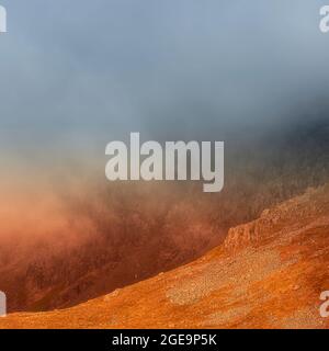 Kunstfoto der Berglandschaft, aufgenommen bei dramatischen Wetterbedingungen bei Sonnenuntergang auf dem Little Gowder-Felsen mit Blick auf den Kirchturm im Lake District, Cumbr Stockfoto