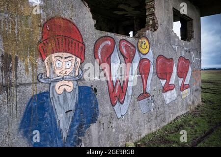 Auf die Wände des verlassenen und verlassenen Kontrollturms auf dem stillgelegten Luftfeld RAF Davidstow des 2. Weltkriegs auf Bodmin Moor in Cornwall wurde Graffiti gesprüht. Stockfoto