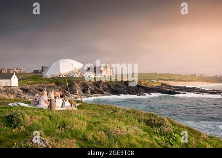 Ein Paar, das ein Picknick und einen besonderen Anlass stilvoll auf Towan Head in Newquay in Cornwall feiert. Stockfoto