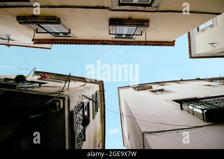 Niedriger Außenwinkel von alten Wohngebäuden mit verwitterten Wänden vor blauem Himmel in Barcelona Stockfoto