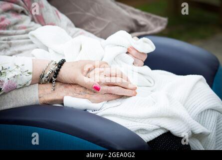 Die Hand eines älteren Verwandten halten Stockfoto