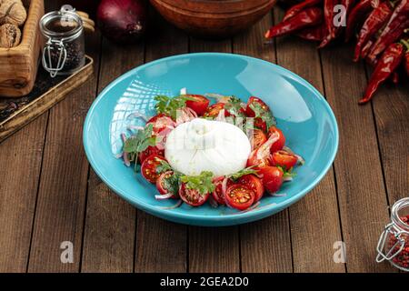 Burrata Käsesalat mit Kartoffeln auf einem blauen Teller Stockfoto