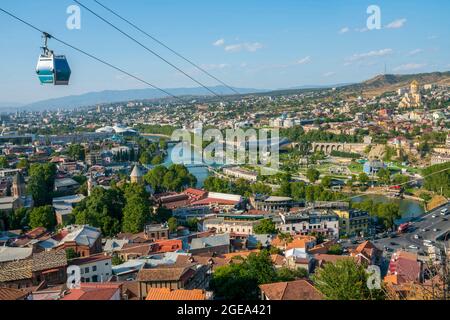 Eine Seilbahn fährt auf dem Weg zur Festung Narikala über einen Panoramablick auf Tiflis. Stockfoto