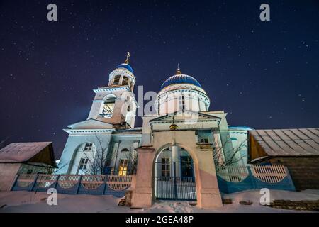 Ein Sternenhimmel über einer orthodoxen Kirche in einem kleinen russischen Dorf im Uralgebirge. Stockfoto