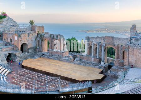 Sonnenuntergang auf dem antiken römisch-griechischen Amphitheater mit der Giardini Naxos Bucht im Hintergrund in Taormina, Sizilien, Italien Stockfoto