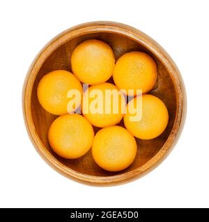 Honey Cantaloupe Melonenkugeln in einer Holzschüssel. Frisch mit einem Melonenballer ausgeschnitten, verzehrfertige süße Kugeln einer reifen Frucht einer Hybridmelone. Stockfoto