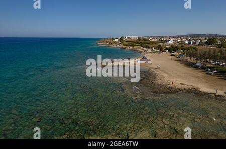 Luftdrohnenansicht der Agia Triada Küste und der Menschen, die im Meer schwimmen. Protaras Paralimni Zypern Stockfoto