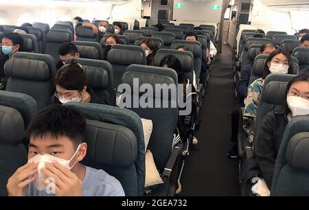 Hongkong, China. August 2021. Passagiere tragen auf ihrem internationalen Flug von Hongkong am Mittwoch, den 18. August 2021, obligatorische Gesichtsmasken. Hongkong ist angesichts der Gefahr eines neuen Covid-Ausbruchs weiterhin auf hoher Alarmstufe, da es nach wie vor ein wichtiger Knotenpunkt und Reiseziel in Asien ist. Foto von Stephen Shaver/UPI Credit: UPI/Alamy Live News Stockfoto