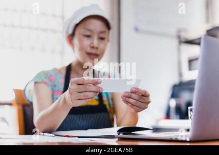 Kleine Küchenchefin Frau reding Grußkarte mit Schürze und Hut. Stockfoto