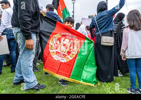 WESTMINSTER LONDON 18. August 2021. Ein junges Mitglied der britischen afghanischen Gemeinschaft steht auf dem Parliament Square hinter der Flagge der ehemaligen Regierung Afghanistans, als Reaktion auf die Machtannahme der Taliban in Afghanistan. Premierminister Boris Johnson hat sich an das Parlament erinnert, als die MPS aus ihrer Sommerpause zurückkehrt, um die Krise in Afghanistan zu debattieren und 20,000 gefährdete afghanische Flüchtlinge zu bringen. Credit amer Ghazzal/Alamy Live News Stockfoto