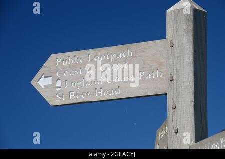 Holzschild nach St. Bees Fahren Sie auf dem Clifftop Coastal Path in der Nähe von St. Bees, Lake District National Park, Cumbria, England, Großbritannien. Stockfoto