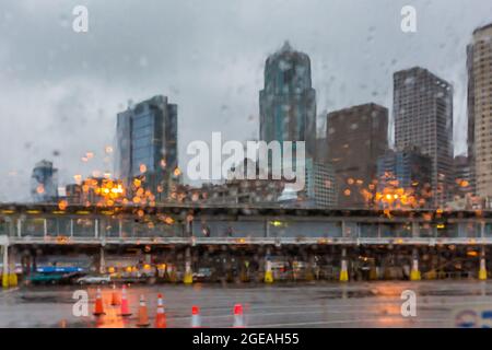 Impressionistischer Blick durch winterliche Regentropfen auf der Windschutzscheibe am Bremerton Ferry Terminal, Bremerton, Washington State, USA Stockfoto