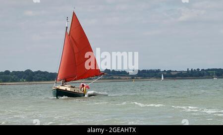 Harwich, Essex - 18. August 2021: Rotes Segelschiff im Hafen. Stockfoto