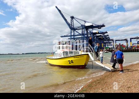 Felixstowe, Suffolk - 18. August 2021: Menschen, die die Hafenfähre von Harwich am Landguard Beach abfahren. Stockfoto