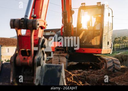 Bagger auf einer Baustelle bei Sonnenuntergang Stockfoto