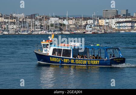 Cremyll, Cornwall, England, Großbritannien. 2021. Passagiere an Bord einer kleinen Fähre, die zwischen Plymouth und Cremyll fährt, vor dem Hintergrund des Plymouth City Cents Stockfoto