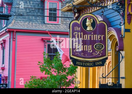 Lunenburg, Nova Scotia, Kanada - 12. August 2021: Zeichen des Mariner King Inn und bunte Häuser Stockfoto