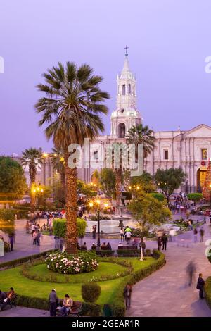 Arequipa, Provincia de Arequipa, Peru - Menschen auf dem Hauptplatz mit der nachts beleuchteten Kathedrale von Arequipa. Stockfoto