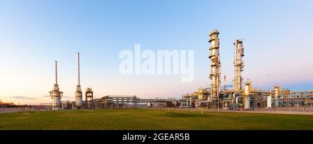 Blick auf eine Gasraffinerie, die in der Dämmerung beleuchtet wird. Stockfoto