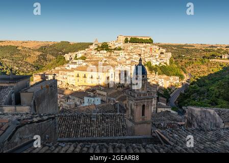 Panoramablick auf Ragusa Ibla bei Sonnenuntergang aufgehellt mit Dach und Kuppel im Vordergrund Stockfoto