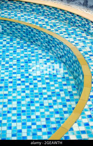 Klares Wasser in einem noch kleinen Swimmingpool mit blauen und weißen Fliesen Stockfoto